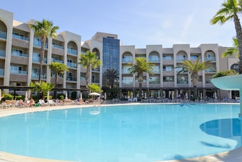 Alberca techada, alberca al aire libre y sombrillas en la alberca