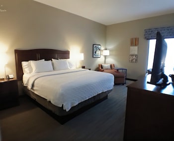 A spacious lobby with multiple seating areas, a reception desk, and large windows providing natural light.