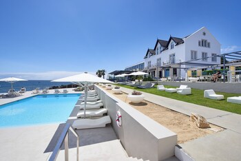 Relax by the pool with ocean views, surrounded by lounge chairs and umbrellas.
