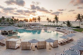 A resort with a large central pool, multiple smaller pools, and a beach area.