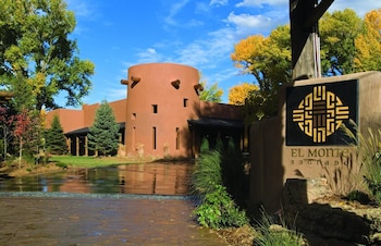 Experience the serene atmosphere of this lodge, surrounded by a tranquil pond and lush trees, with a warm glow emanating from within.