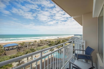 A coastal hotel with a boardwalk, beach access, and a gazebo.