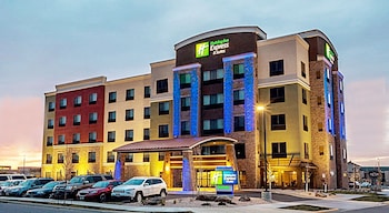 Un hotel Holiday Inn Express & Suites con un estacionamiento frente al establecimiento.