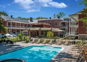 Relax by the pool surrounded by a two-story building with multiple balconies.