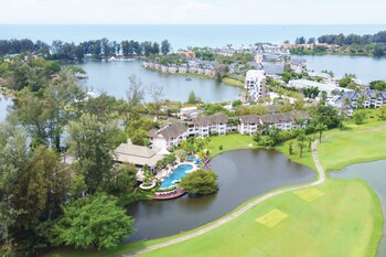 Relax by the pool surrounded by palm trees and lounge chairs, with a water slide and umbrellas providing shade.