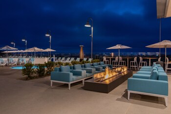 Una piscina al aire libre, camas de piscina con cargo, sombrillas