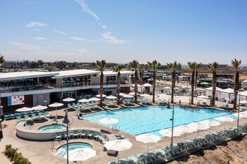Una piscina al aire libre, camas de piscina con cargo, sombrillas