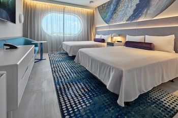 Una piscina al aire libre, sombrillas, sillones reclinables de piscina