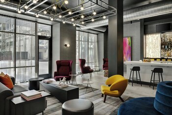 A modern lounge area with large windows, a bar, and contemporary seating.