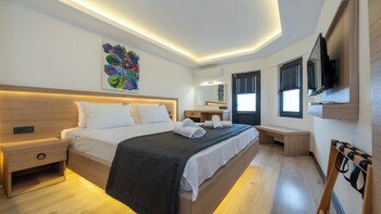 Een zwembad met ligbedden en tafels, een bar en een gebouw met balkons.