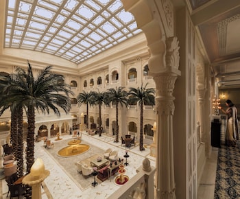 A pool with a view of mountains and a white building with arches.