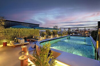 Alberca al aire libre, sombrillas en la alberca y camastros