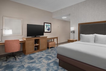 A modern hotel lobby with a bar area, multiple seating options, and a central reception desk.