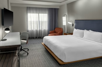 Et Courtyard by Marriott hotel med moderne design, flere etager og en godt oplyst indgang.