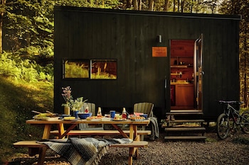 Situated in a secluded forest, this cabin offers a small deck with a fire pit for outdoor activities.
