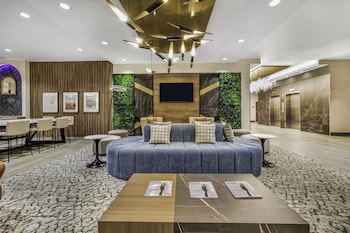 Un comedor moderno con varias mesas y sillas, un pilar decorativo central y ventiladores de techo.