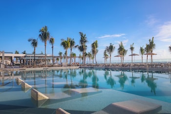 A modern pool area with a bar named "TEQUILA," overlooking the ocean.
