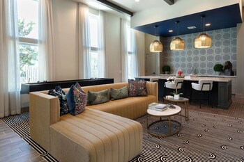 Un salon moderne avec une cheminée, deux fauteuils, une table basse et des plantes décoratives.