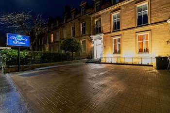 Un bâtiment en briques avec une enseigne indiquant « Mayfield Suites ».
