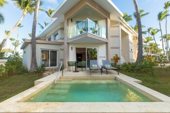 Un resort con piscina, palmeras y vista al océano.