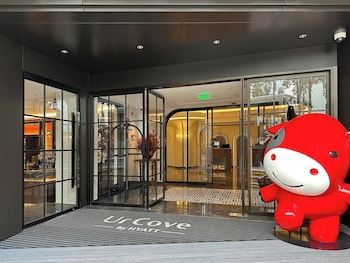 A spacious lobby with a high ceiling, a reception desk, and a seating area.