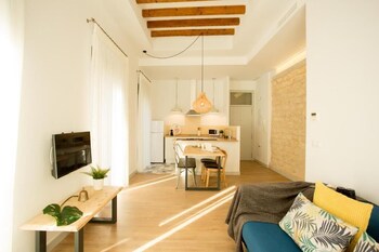 Un dormitorio moderno con cama, zona de estar, bañera y un espejo grande.