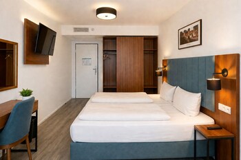 A multi-story hotel with a prominent entrance, outdoor seating area, and a covered walkway.