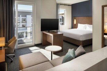 A modern hotel with a courtyard, multiple floors, and a view of the sunset.