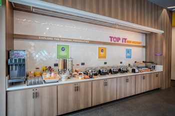 A modern reception area with a central counter, multiple seating options, and a high ceiling with recessed lighting.