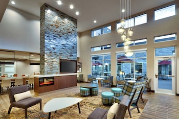 A spacious lobby with a stone accent wall, a bar area, and seating arrangements.