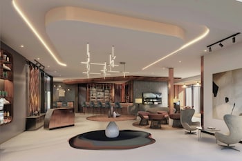 Un restaurante moderno con varias zonas de comedor, iluminación colgante y una barra central.