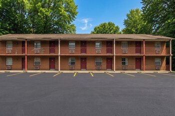 Un motel avec une enseigne publicitaire indiquant « HomeTown Inn » et « Chambres propres – tarifs avantageux ».