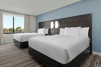 Un hotel moderno de varios pisos, con un patio interior y un letrero que indica que es un Courtyard by Marriott Residence Inn.
