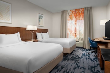 Un hôtel Fairfield Inn & Suites de la chaîne Marriott, doté d’un design moderne, avec une entrée imposante et un espace de stationnement.