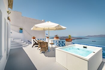 Enjoy breathtaking ocean views from the comfort of this serene hotel room, featuring a plush bed, a soothing hot tub, and a touch of greenery.