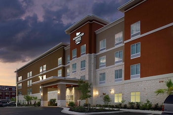 A multi-story hotel with a stone facade, multiple windows, and a sign indicating it is a Homewood Suites Hilton.