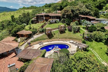 Relax in a serene poolside setting surrounded by lush greenery and comfortable seating.