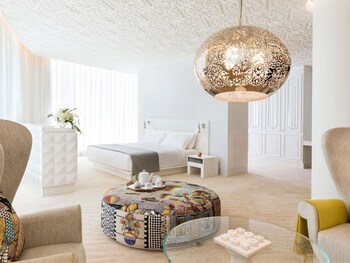 A luxurious indoor pool area with a geometric ceiling design, checkered floor, and lounge chairs.
