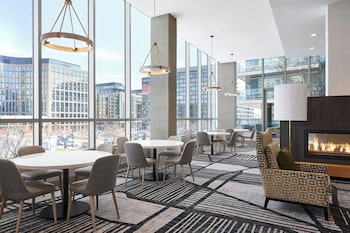 A modern lounge area with a fireplace, comfortable seating, and large windows offering city views.
