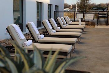 Un espace extérieur aménagé avec des meubles en osier et un foyer central.