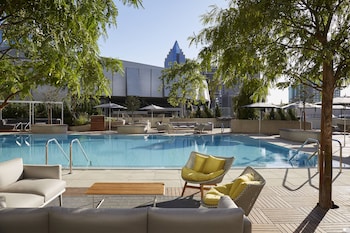 Welcome to The Sawyer Kimpton, featuring a modern architectural design with a glass facade and a covered entrance with a patterned ceiling.