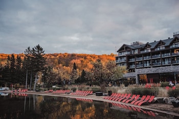 A large resort with multiple buildings, a dock, and a lake.