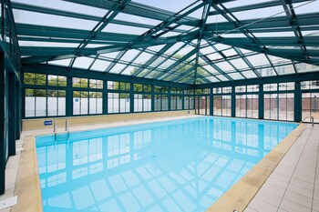 Una piscina cubierta, tumbonas