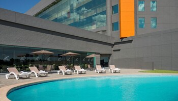 Experience the Realm's spacious lobby with a polished floor, multiple seating areas, and lush greenery.