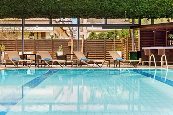 Piscine extérieure en saison, chaises longues, maître nageur