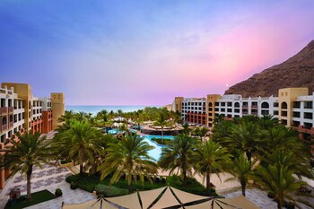 Relax by the pool surrounded by palm trees and sun loungers.