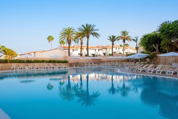 Alberca al aire libre, sombrillas en la alberca y camastros 