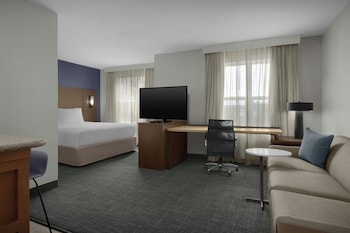 A spacious lobby with a stone fireplace, seating areas, and a modern design.
