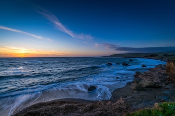 Stroll along the beachside walkway, lined with lush vegetation and scenic views of the ocean.
