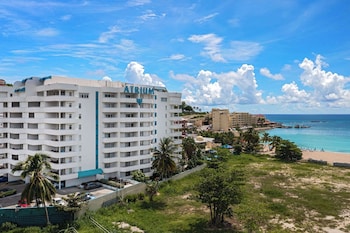 Na praia, areia branca, espreguiçadeiras, guarda-sóis 